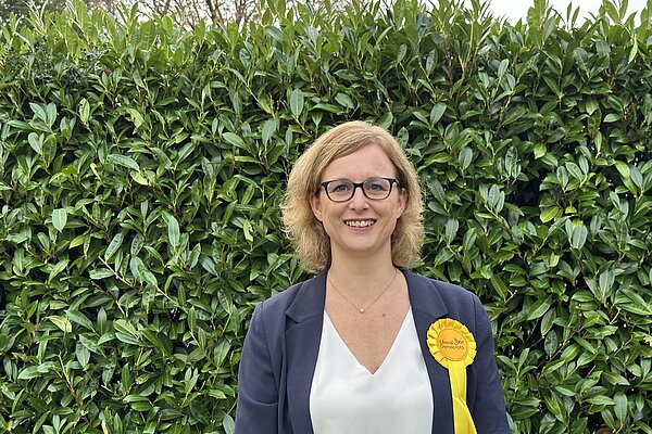 Kirsten with a hedge in background