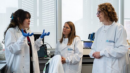 Alison Visiting King’s College London’s dementia research laboratory last week pictured with two scientists in white lab coats, one gesticulating while talking to Alison