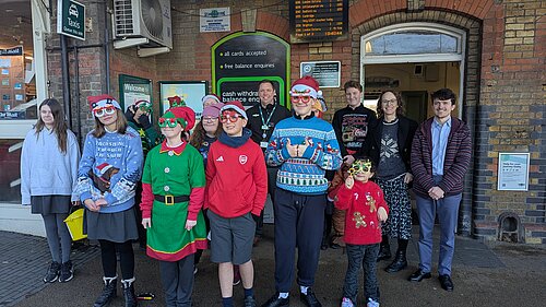Alison singing carols at station with Woodlands Meed students